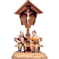 Grandparents sitting under field cross